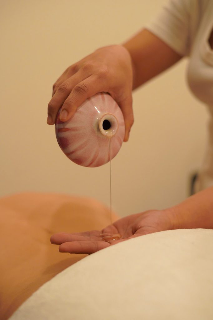 Therapist using bamboo sticks for a bamboo massage in Hoi An at Relaxanh Wellness Spa