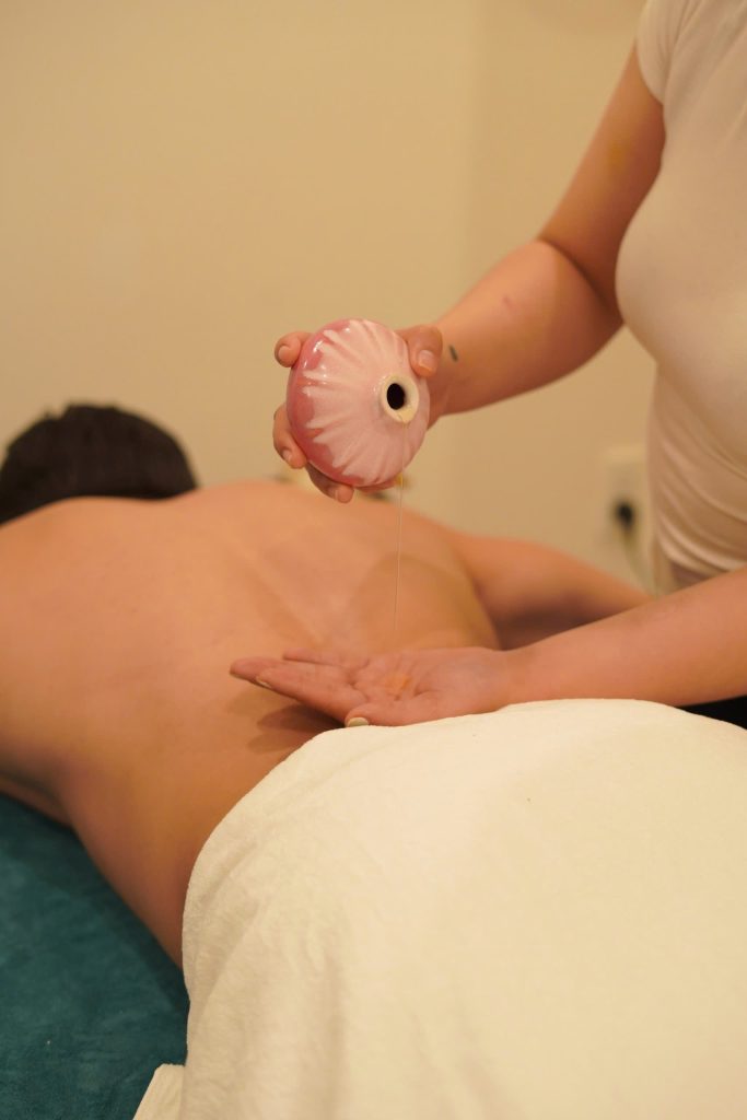 Bamboo massage tool being used on a guest's shoulder at Relaxanh Wellness Spa in Hoi An